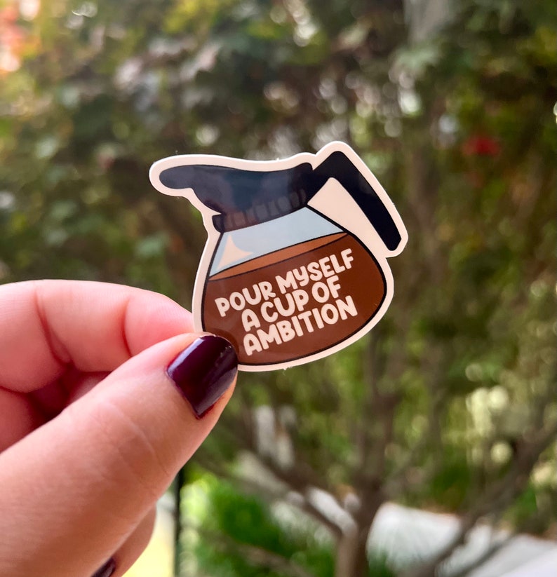 May include: A brown and white sticker of a coffee pot with the text "Pour myself a cup of ambition".
