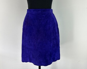 May include: A purple suede skirt with a straight silhouette. The skirt is knee-length and has a simple design.