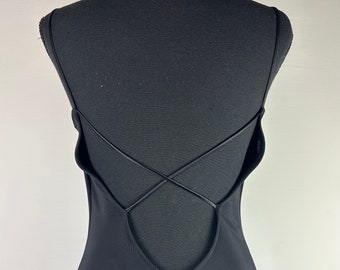 May include: Black sleeveless maxi dress with a low back and criss-cross straps.