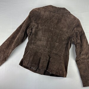 May include: A brown suede jacket with a button closure and long sleeves.