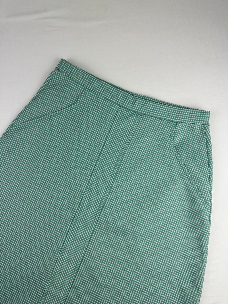 May include: A green gingham skirt with a straight cut and a high waist.