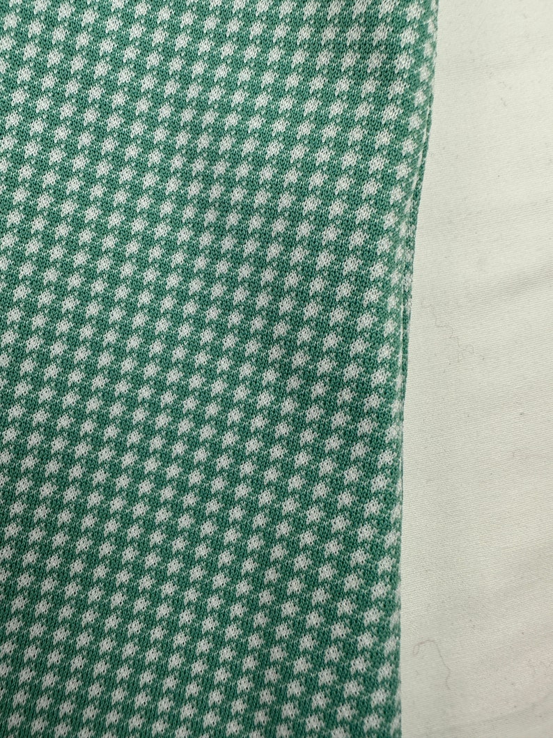 May include: Green and white fabric with a small checkered pattern.