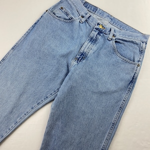 May include: Light blue denim jeans with a classic five-pocket style. The jeans have a straight leg and a button fly.