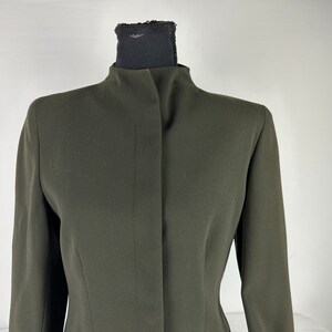 May include: A dark green blazer with a high collar and a single button closure.
