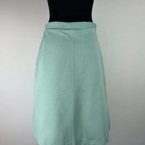 May include: A green and white gingham skirt with a straight silhouette. The skirt is knee-length and has a simple design.