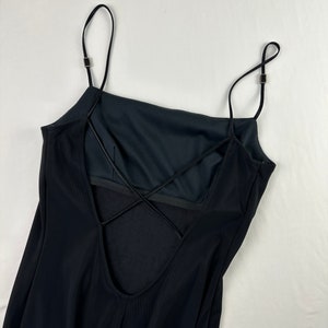 May include: Black spaghetti strap dress with a criss-cross back detail.