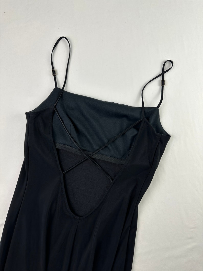 May include: Black spaghetti strap dress with a criss-cross back detail.
