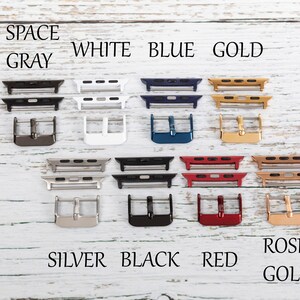 May include: A variety of watch band adapters in different colors, including space gray, white, blue, gold, silver, black, red, and rose gold. The adapters are arranged in two rows of four, with the colors labeled above each row.