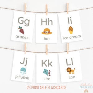 May include: A set of 26 printable flashcards featuring the alphabet with corresponding illustrations. The flashcards include letters G, H, I, J, K, and L with images of grapes, a hat, ice cream, a jellyfish, a kite, and a lion.
