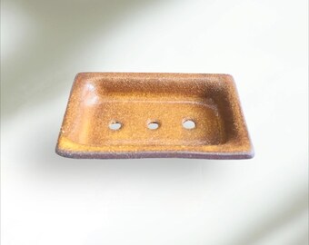 Puede incluir: Un jabonera rectangular de cerámica con un esmalte marrón y tres agujeros de drenaje.