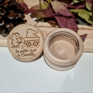 K&ouml;nnte beinhalten: Eine kleine Holzkiste mit Deckel. Der Deckel hat ein Design mit einer Maus, die einen Wagen zieht, mit dem Text "Les petites dents de Camille".