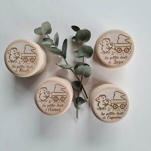 K&ouml;nnte beinhalten: Vier Holzkisten mit einem Maus- und Wagenmotiv. Jede Kiste tr&auml;gt einen anderen Namen: Laya, Ma&euml;li, Hana&euml; und Capucine. Die Kisten stehen auf einer wei&szlig;en Oberfl&auml;che mit gr&uuml;nen Bl&auml;ttern.