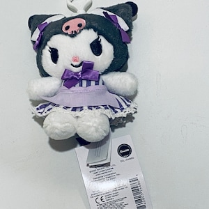May include: A plush purple and white Hello Kitty keychain with a skull and crossbones on her head. The keychain is made of polyester and is 17.5 cm tall. The tag on the keychain says "Sanrio" and "SIL-34860".