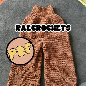 May include: Brown crochet pants featuring a high-waisted ribbed waistband and wide-leg silhouette. The text "RAECROCHETS" is displayed in white letters with a black outline, and a circular logo with the yellow text "PDF" is visible on the left.
