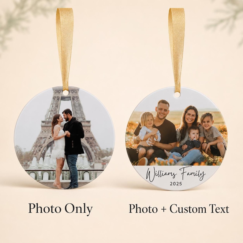 Puede incluir: Dos adornos redondos de cer&aacute;mica con cintas doradas para colgar. El adorno de la izquierda muestra a una pareja frente a la Torre Eiffel. El adorno de la derecha presenta un retrato familiar con el texto Williams Family 2025 impreso abajo.