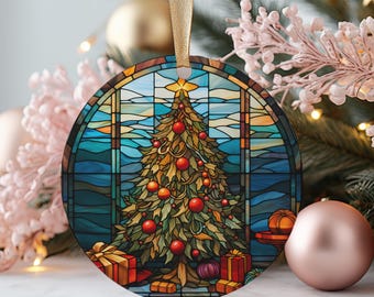 Puede incluir: Adorno navideño redondo con un diseño de vidriera que representa un árbol de Navidad decorado. El árbol está adornado con bolas rojas y se encuentra frente a un fondo azul y turquesa. Cinta dorada para colgar.
