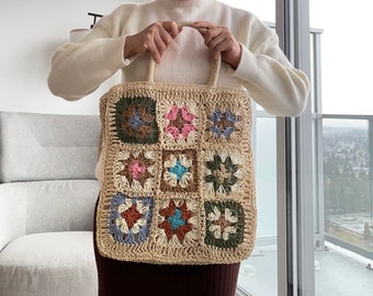 May include: A crocheted tote bag with a patchwork design featuring squares of different colors, including pink, blue, and green.