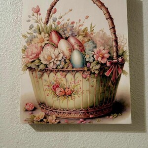 May include: A vintage-style illustration of a wicker basket overflowing with colorful Easter eggs and spring flowers. The basket is decorated with floral patterns and a red ribbon.