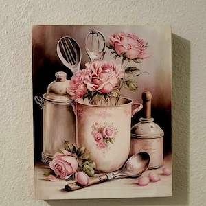 May include: A vintage-style painting of a still life featuring pink roses in a white ceramic pitcher with a floral pattern. The roses are surrounded by antique kitchen utensils, including a whisk, a ladle, and a spoon. The painting has a soft, romantic feel.