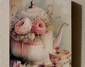 Può includere: Una teiera in stile vintage con un design floreale e rose rosa, una tazza da tè e un piattino abbinati con un motivo floreale, e una singola rosa rosa in cima alla tazza da tè.
