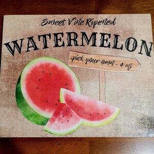 Pode incluir: Uma placa de madeira r&uacute;stica com o texto "Sweet Vine Ripened Watermelon - pick your own - 4 mi" e uma ilustra&ccedil;&atilde;o de aquarela de uma melancia.
