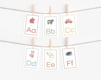 May include: Six colorful flashcards with illustrations and letters of the alphabet. The cards are hung on a string with clothespins. The letters are A, B, C, D, E, and F. The illustrations are an apple, a bear, a car, a dog, an elephant, and a fish.