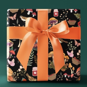 May include: A gift box wrapped in black paper with a colorful mushroom, butterfly, and floral pattern. The box is tied with a bright orange ribbon.