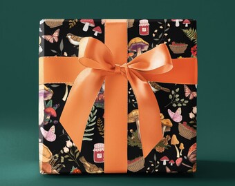 Peut inclure: Une boîte cadeau enveloppée de papier noir avec un motif coloré de champignons, de papillons et de fleurs. La boîte est attachée avec un ruban orange vif.
