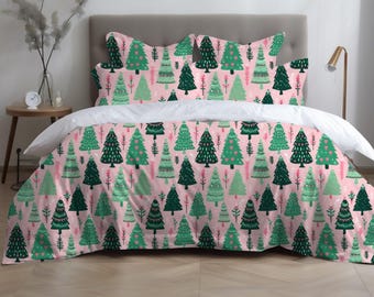 May include: A bed set featuring a pink duvet cover and pillowcases adorned with a repeating pattern of green Christmas trees. The trees vary in design and are decorated with hearts. The bed set includes a white top sheet.