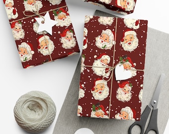 May include: Red wrapping paper with a repeating pattern of Santa Claus faces. The paper is decorated with white snowflakes and has a rustic, vintage feel.
