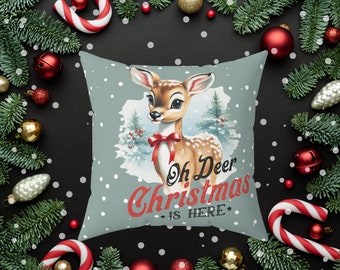 May include: A blue and white throw pillow with a vintage illustration of a deer with a red bow. The text "Oh Deer Christmas is Here" is printed in red on the pillow.