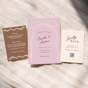 May include: A wedding invitation suite with a pink background and white calligraphy. The invitation features a bow and the text "You're invited to the wedding of Camille & Andrew". The date is Saturday, April 10, 2026 at Oakhurst Estate in Berkeley, CA. The RSVP card is cream colored with the text "Kindly R.S.V.P." and a QR code.