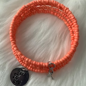 May include: A coral-colored beaded bracelet with a silver charm that says "You got this!"