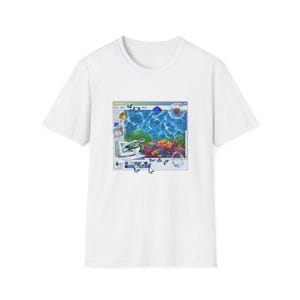May include: A white t-shirt featuring a graphic print of a computer window interface. The window displays an underwater scene with a sea turtle, colorful coral, and blue water. Small butterflies, bubbles, and a computer mouse cursor are visible.