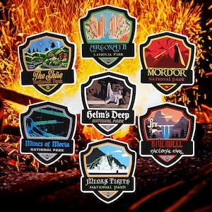 May include: A set of ten illustrated national park stickers featuring locations from the Lord of the Rings. The stickers are shaped like shields and feature colorful illustrations of iconic locations from the books and movies. The stickers include The Shire, Mines of Moria, Argonath, Helm's Deep, Minas Tirith, Mordor, Rivendell, and more.