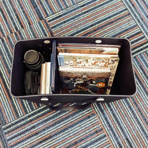 May include: A black tote bag with a polka dot pattern filled with books and a water bottle. The bag has two handles.