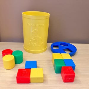 Klassieke vintage Fisher Price plastic sorteerblokkenset met container uit 1977