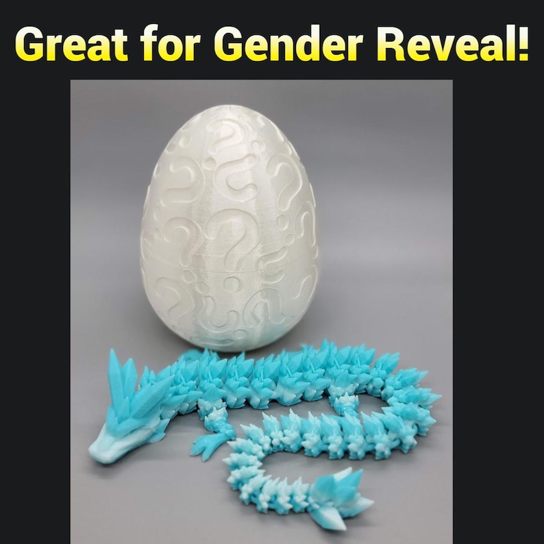 May include: A white egg-shaped container with question marks printed on the surface. A blue dragon figurine with a spiky tail is lying next to the egg.  Great for Gender Reveal!