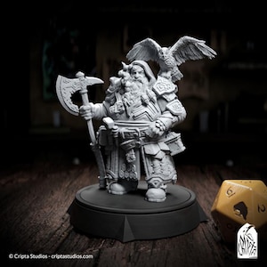 May include: A gray painted miniature figurine of a dwarf warrior with a beard and an axe. The dwarf is wearing armor and a kilt. The figurine is standing on a round base. A yellow six-sided die is in the foreground.