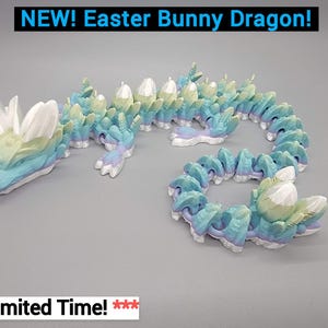 May include: A pastel blue, green, and white Easter bunny dragon figurine. The dragon is curled up with its tail in its mouth. The dragon has a long, thin body with a small head and large, white ears. The dragon is made of a smooth, plastic-like material.
