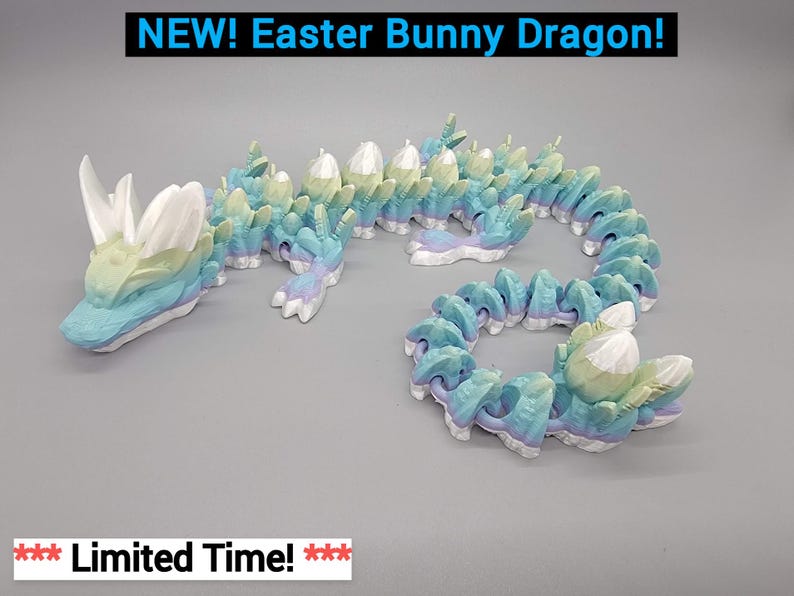 May include: A pastel blue, green, and white Easter bunny dragon figurine. The dragon is curled up with its tail in its mouth. The dragon has a long, thin body with a small head and large, white ears. The dragon is made of a smooth, plastic-like material.