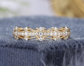 Könnte beinhalten: Ein zarter Goldring mit einem dekorativen Filigranmuster und einer Reihe funkelnder Diamanten.