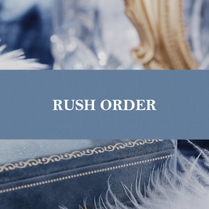 May include: A blue velvet box with a white embroidered design and the words "Rush Order" on a blue background.