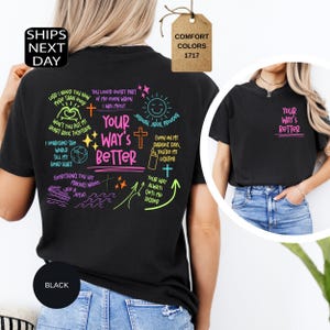 May include: Black t-shirt with the phrase "Your Way's Better" in pink and neon green. The back of the shirt features handwritten text and graphics in neon colors. The shirt is made of a comfortable material.