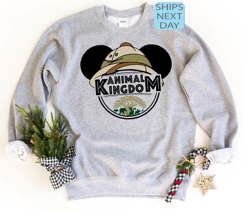 May include: Grey sweatshirt with a Mickey Mouse head design featuring a safari hat and the words "Animal Kingdom".
