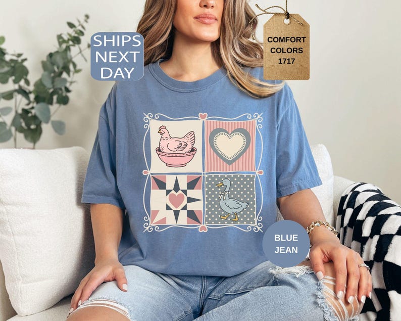 May include: Blue jean-coloured t-shirt with a patchwork design featuring a hen, a heart, a star, and a duck. The shirt has short sleeves and a crew neck. The text "Comfort Colors 1717" is on a tag.