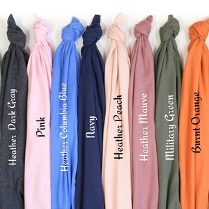 May include: A collection of folded t-shirts in various colors, including Kelly Green, Athletic Heather, and Heather Dark Gray. Each shirt is labeled with its color name in a clean, sans-serif font. Other colors include Pink, Navy, and Burnt Orange.