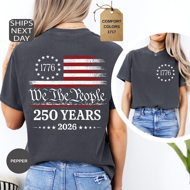 Pu&ograve; includere: T-shirt grigio scuro con grafica della bandiera americana, testo "1776", "We The People" e "250 YEARS 2026". La maglietta ha girocollo e maniche corte. Il colore &egrave; "Pepper".