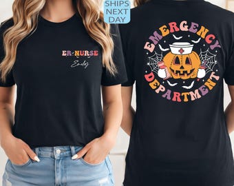 Könnte beinhalten: Schwarzes T-Shirt mit der Aufschrift "ER-NURSE" und "Emily" in bunten Farben auf der Vorderseite. Auf der Rückseite befindet sich ein Halloween-Motiv mit einem Kürbis mit Krankenschwestermütze, umgeben von Fledermäusen und dem Schriftzug "EMERGENCY DEPARTMENT".
