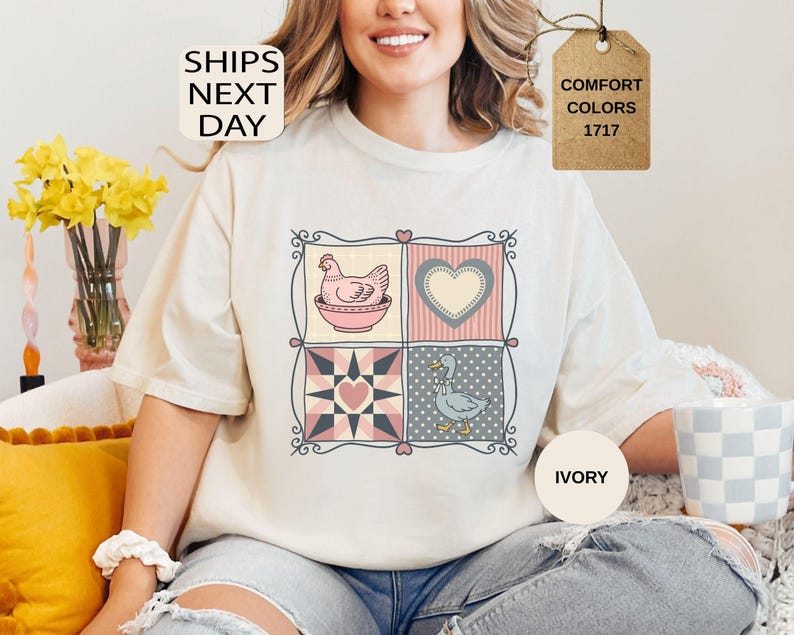 May include: Ivory t-shirt with a patchwork design featuring a hen, heart, and duck. The shirt has the text "SHIPS NEXT DAY" and "COMFORT COLORS 1717". The t-shirt is a comfortable fit.